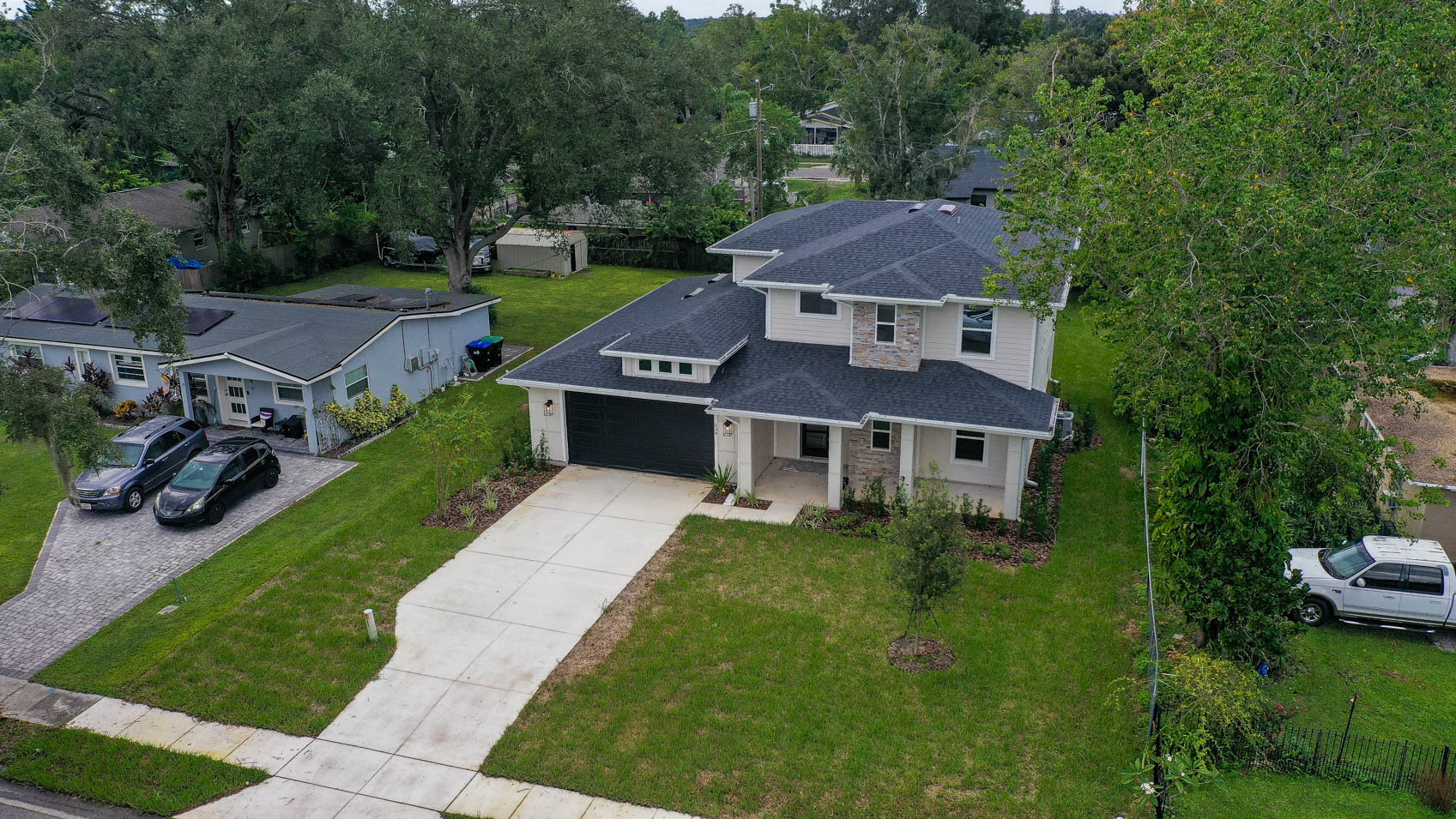 front of two story home at an angle showing the roof and long driveway